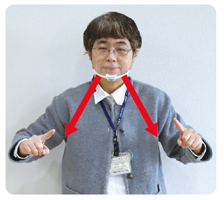 手話通訳者・鈴木さんがクロスした左右の人差し指を「ハ」の字に下げている写真
