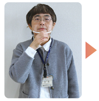 手話通訳者・鈴木さんが軽く握った手を顎に置いている写真
