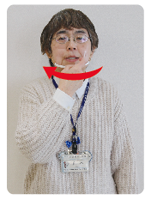 手話通訳者・鈴木さんが歯を見せながら人差し指を端から端に動かしている写真