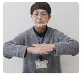 手話通訳者・鈴木さんが両手を肘から曲げて胸の前で平行にしている写真
