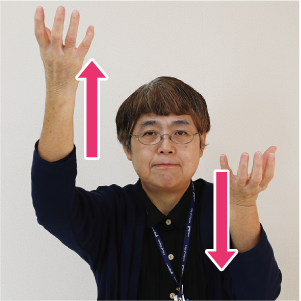 手話通訳者・鈴木さんが実をもぐよう手の平を上にして上下させている写真