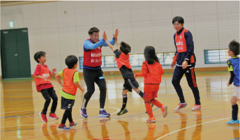 アルビの選手とハイタッチする子どもたちの写真