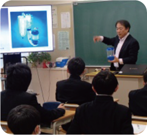 男性がモニターを使って自分自身の職業人としての講話を生徒たちにしている写真