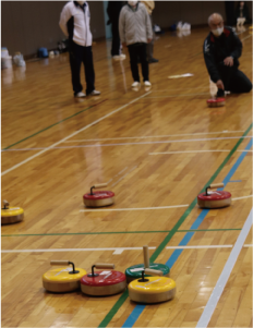 複数のフロッカーが集まっているとこに向けて、男性がフロッカーを床に滑らせ投げている写真