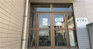 茶色のタイル、大きな玄関の「地域あじかた」の建物の写真