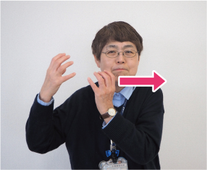 両手を握り、顔の左側に持ってくる写真