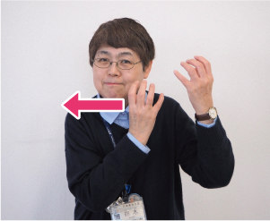 両手を握り、顔の右側に持ってくる写真