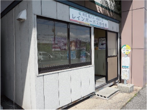 イオン白根前店の停留所とプレハブの待合所の写真