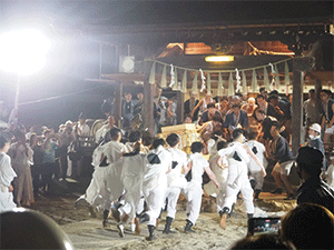 白装束に神輿をかつぎ、奉納しようとしている若い衆と、祭りを終わらせたくないと神輿を入れまいとする法被を着た若い衆の写真
