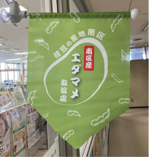 「南区産エダマメ取扱店」と書かれた緑色のフラッグが掲出されている写真