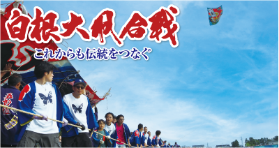 白根大凧合戦会場、中ノ口川の白根側堤防上。桜蝶組が大凧を揚げ、たくさんの引き手が凧綱を引いている写真