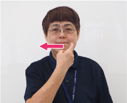 口の端に人差し指をあてる写真