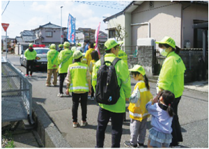大人とこどもが手をつないで参加している町内パレードの写真