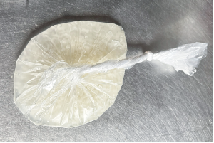 コメと水を入れ、空気を抜いて口の先端を結んだ袋の写真