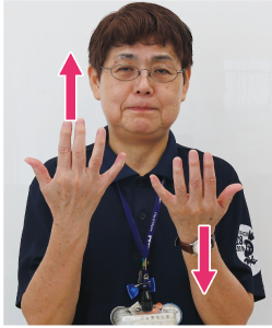 手話通訳者鈴木さんが指を上にしている写真