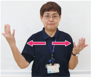 手話通訳者鈴木さんがその手を上下に動かしながら、左右に動かしている写真
