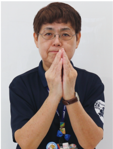 手話通訳者鈴木さんがその手を胸の前でくっ付けている写真