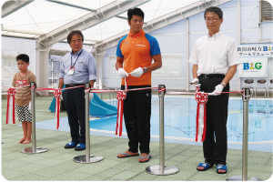 少年、関副区長、水沼選手が紅白のリボンに手を掛け、テープカットをする写真