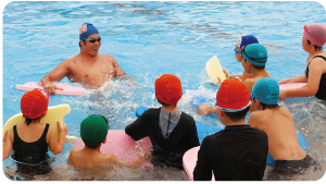 プール内で水沼尚輝選手を前にして話を聴いている子供たちの写真