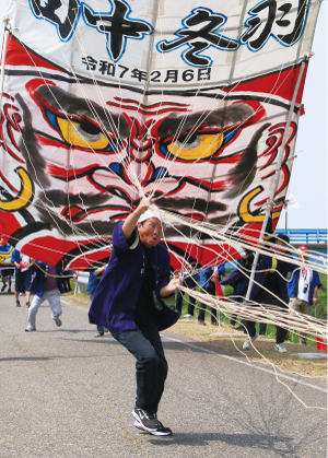 達摩組の凧を揚げる凧組の写真