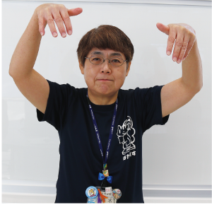 手話通訳者鈴木さんが頭の上で指を下向きにしている写真