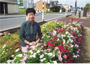 （株）柏自動車が植えた花と花を植えた人が隣で笑っている写真