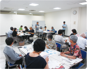 自治協議会委員が会議室で研修を受けている写真