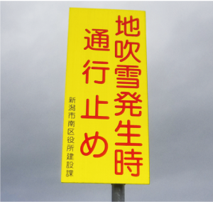 地吹雪発生時通行止めの看板の写真