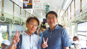 旧月潟駅に保存してあるかぼちゃ電車内で笑顔でピースをする長浜区長・中原市長の写真