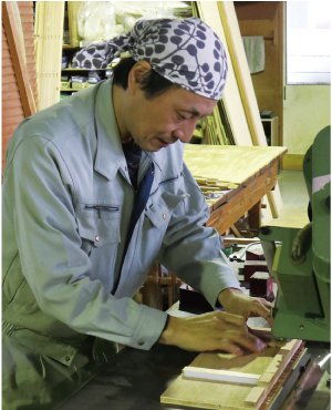 吉田さんが木材を機械で切り出している写真