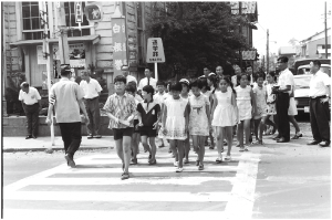 手押し式信号機が設置され、点灯式でこどもたちが信号を渡る様子