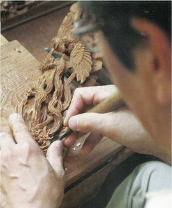 木材に彫刻刀を使って彫刻を施している写真