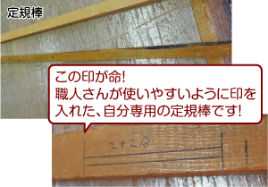 四角い棒状に手書きの印が入っている「定規棒」の写真