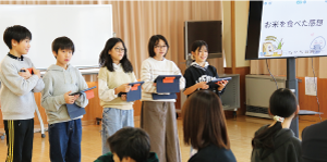 男子児童２人と女子児童３人がタブレットを手に横並びになり、発表をしている写真
