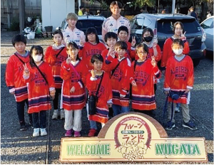 白根グレープガーデンの看板を最前列にし、アルビレックス新潟のユニフォームを着た大鷲小学校４年生、そしてアルビレックス新潟の大竹優心選手と内山翔太選手２人が最後列に並んだ集合写真