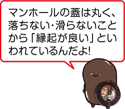 凧合戦専用マンホールを脇に抱えた凧マンホールさんが「マンホールの蓋は丸く、落ちない・滑らないことから「縁起が良い」といわれているんだよ！」と言っているイラスト