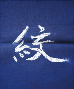 軍隊絞りの写真 「絞」の文字の模様です。作りたい模様に合わせて糸を巻くため、細かい線(糸)の模様が出ている絞りです。