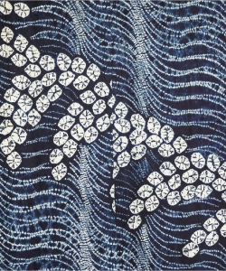 白く波打った線と稲穂のように小さな丸い模様が入れられたタペストリー