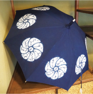 白根絞りの傘の写真 傘地は濃い藍色で、それぞれの面に白く丸い花の模様がついています。