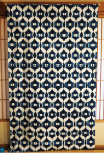 タペストリーの写真 円がたくさん重ねられ、重なり合ったところは白くなっています。円の中心には小さな楕円が二つあります。