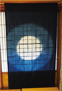 タペストリーの写真 中心に白い丸があり、その周りに薄い藍色の丸、さらにその外側は濃い藍色に染められています。