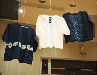 白根絞りのTシャツが3枚並んでいる写真 左側は濃い藍色がベースになって、服の真ん中に小さな白い丸の模様が横に並んでいます。中央は白地で、襟元の中央に小さな藍色のハートが縦に3つ並んでいます。右側は濃い藍色がベースになって、中央に縦に小さな白い模様がたくさんつけられています