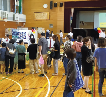 販売ブースに並ぶ地域の人たちの写真