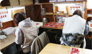 パック付け作業を行う人たちの写真