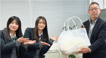 使用済み切手を渡す女子生徒の写真