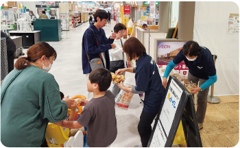 親子に食料を配っている防災士の写真