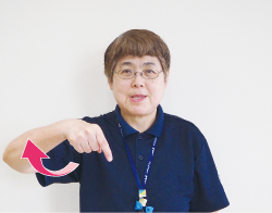 鈴木さんが人差し指を下に向けている写真
