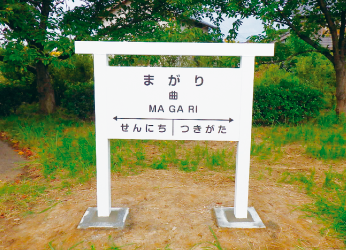 まがりと書かれた駅名標の写真