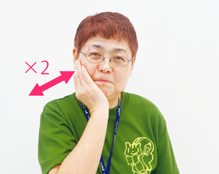 片手で頬を抑えている写真