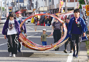 大凧を丸めて運んでいる写真